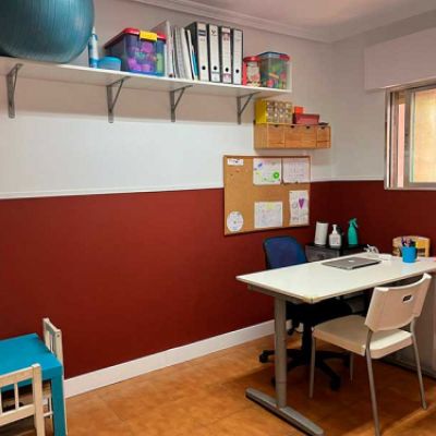 Despacho con pared rojiza y mesa