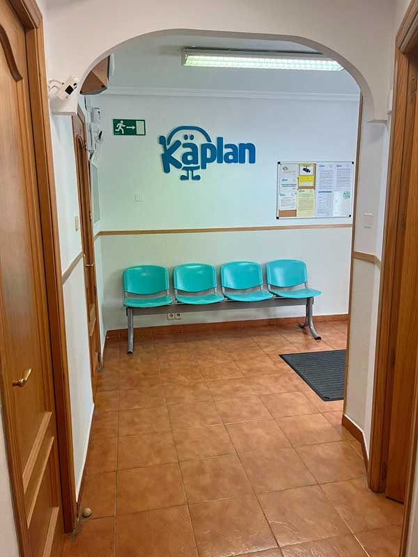 Acceso a la clínica con sillas azules y logotipo de Kaplan