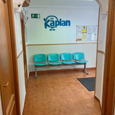 Acceso a la clínica con sillas azules y logotipo de Kaplan