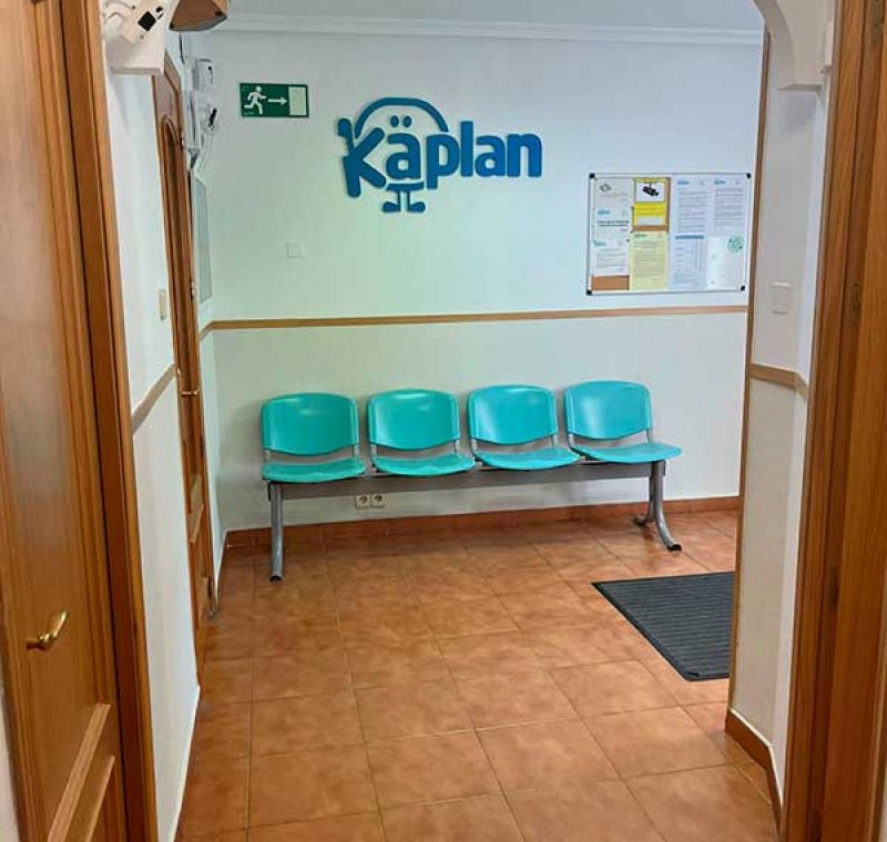 Acceso a la clínica con sillas azules y logotipo de Kaplan